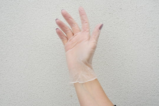 the woman's right hand in a transparent rubber glove