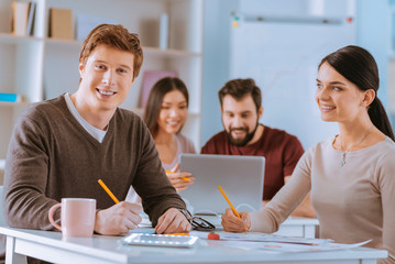 Positive two colleagues writing down