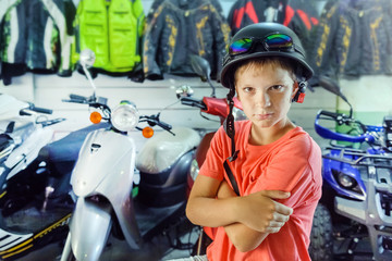 boy - teenager measures vintage motorcycle helmet  in a motorcycle store