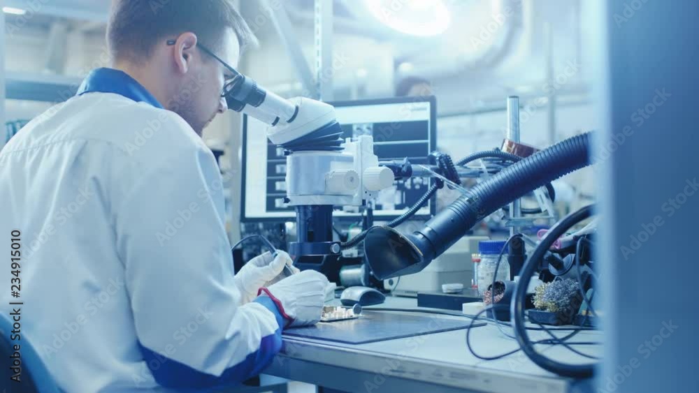 Aufkleber electronics factory worker in white work coat is soldering a printed circuit board through a digital