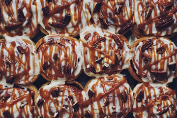 Cinnamon buns with nuts and caramel sauce background
