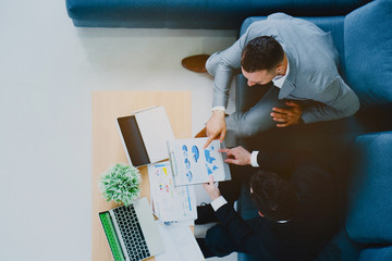 Two businessmen are sitting discussing the job. Many marketing plans from around the world. By loading the data. Make decision to invest in stocks. Successful organization will have a good consultant.