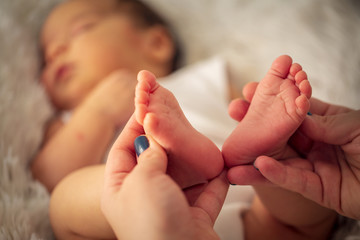 Beautiful infant baby feet in mother hands. feet of little baby, newborn baby foot, newborn baby finger, . - obrazy, fototapety, plakaty