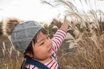 ススキで遊ぶ子供