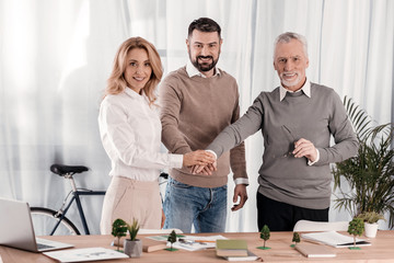 Fototapeta premium Happy colleagues holding hands together
