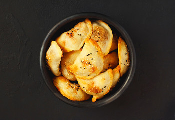 Homemade meat dumplings fried with onion on dark concrete background - top view