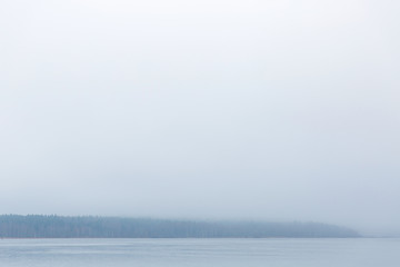 Beautiful landscape of arctic lake in the forest. Blue fog on the water