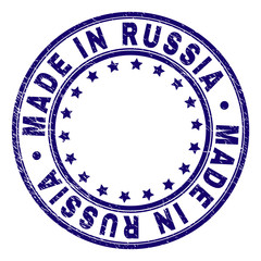 MADE IN RUSSIA stamp seal imprint with grunge texture. Designed with round shapes and stars. Blue vector rubber print of MADE IN RUSSIA caption with scratched texture.