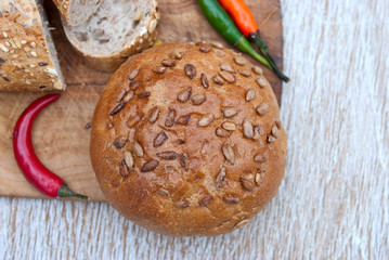 Bread and hot and chili peppers on wooden background
