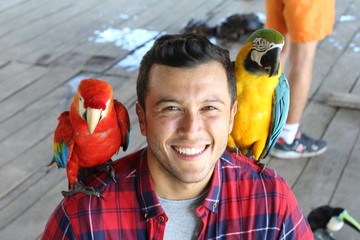 Obraz premium Egzotyczne ptaki łączą się z mężczyzną