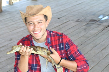 Ethnic man holding baby caiman