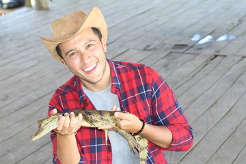 Zookeeper enjoying work with a baby caiman 