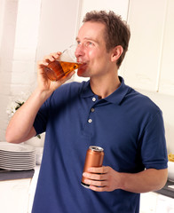 MAN IN KITCHEN DRINKING ALE