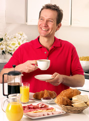 MAN HAVING BREAKFAST AND DRINKING COFFEE