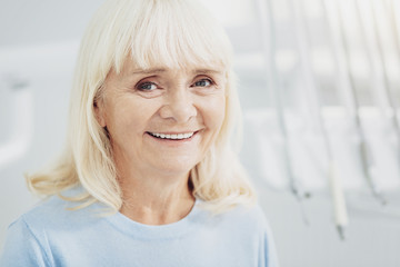 Glad senior woman satisfying with doctor