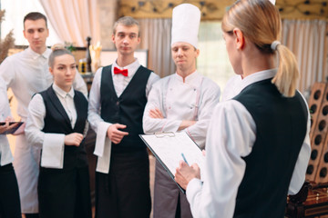 restaurant manager and his staff in kitchen. interacting to head chef in commercial kitchen.
