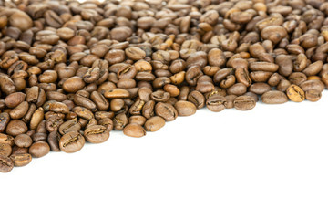 Lot of whole dark brown coffee beans sweet arabica variety with copyspace in front isolated on white background