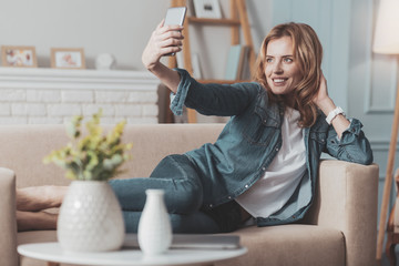 Joyful attractive woman looking into the smartphone camera