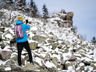 Man in sportswear with backpack shooting on smartphone.