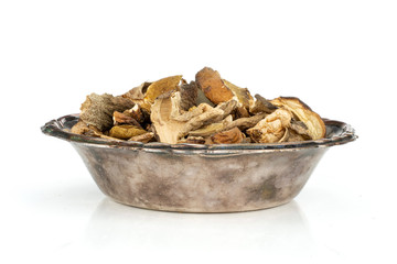 Lot of slices of dry brown mushroom boletus edulis variety in old iron bowl isolated on white background