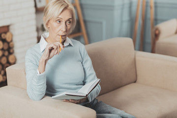 Serious thoughtful woman biting a pencil