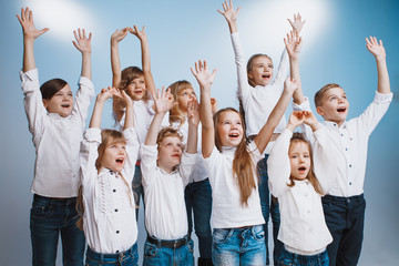 Fototapeta premium Adorable kids have fun together at birthday party. They playing together in different games, spending time in decorated studio. Children and events concept