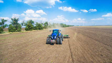 Obraz premium A tractor plowing and sowing in the field
