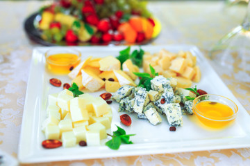 Assortment of different types of cheese with honey.