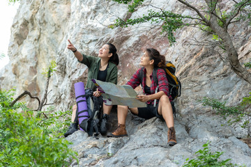 Obraz premium Group women lifestyle of hikers helping and checking map with backpack on a forest mountain. Traveler going camping. Travel and Trips Concept