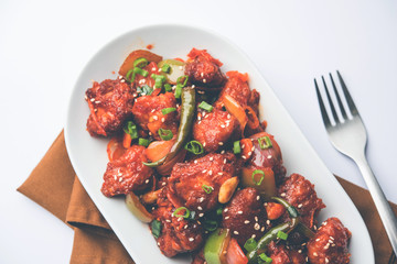 Indian Chilli Chicken dry, served in a plate over moody background. Selective focus