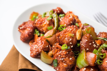 Indian Chilli Chicken dry, served in a plate over moody background. Selective focus
