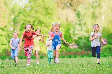 Fototapeta premium Many different kids, boys and girls running in the park on sunny summer day in casual clothes