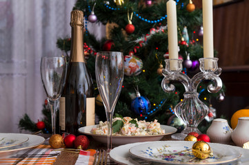 festive table set, plates, fork, Olivier salad, red, Golden Christmas balls, napkins, food, new year, Christmas, glasses, Christmas tree, bottle of sparkling wine,