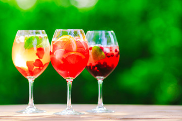 Summer cocktail. Fruit cocktail on green background. Citrus fruits, berries, strawberries, blueberries, mint, ice.