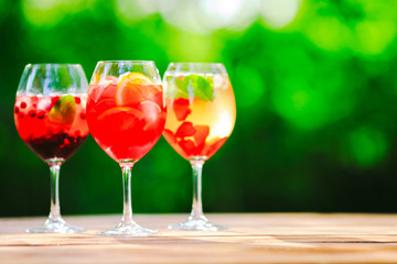 Summer cocktail. Fruit cocktail on green background. Citrus fruits, berries, strawberries, blueberries, mint, ice.