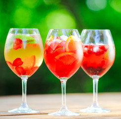 Summer cocktail. Fruit cocktail on green background. Citrus fruits, berries, strawberries, blueberries, mint, ice.