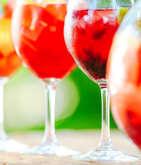 Summer cocktail. Fruit cocktail on green background. Citrus fruits, berries, strawberries, blueberries, mint, ice.