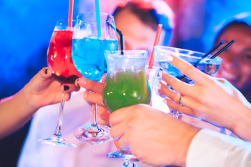 Friends with cocktails drinks at a party.
