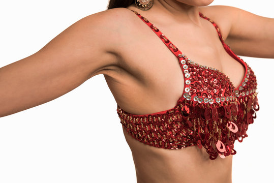 Beautiful belly dancer young woman in gorgeous red and gold costume dress. Part of body