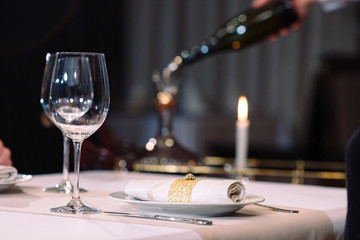 A sommelier pouring red wine into decanter