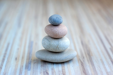 Fototapeta na wymiar Stone cairn on striped grey white background, four stones tower, simple poise stones, simplicity harmony and balance, rock zen