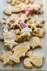Painted traditional Christmas gingerbreads arranged on wooden tray in daylight, lots of Xmas symbols, red color