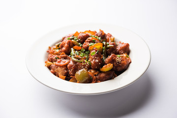 Indian Chilli Chicken dry, served in a plate over moody background. Selective focus