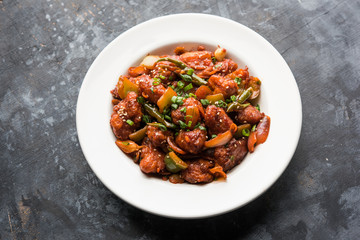 Indian Chilli Chicken dry, served in a plate over moody background. Selective focus