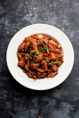 Indian Chilli Chicken dry, served in a plate over moody background. Selective focus