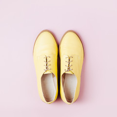 Stylish yellow shoes on pale pink background, flat lay