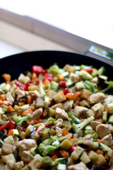 Cooking various vegetables and chicken in wok. Selective focus.