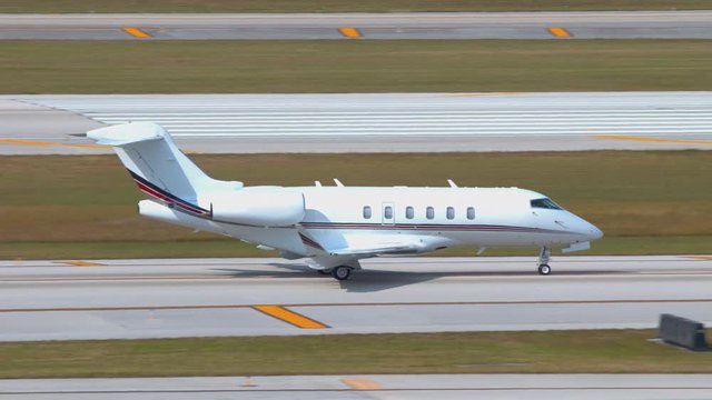 Generic White Executive Business Jet Moving on Airport Ground Taxiways and Runways on a Sunny Day