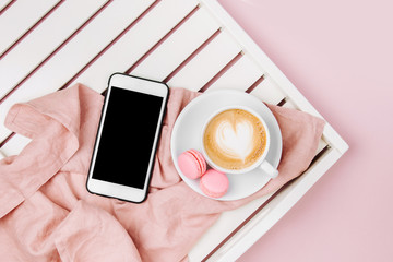 Cup of coffee on white wooden serving tray and Smartphone. Flat lay, top view