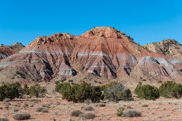Fototapeta premium Colorful mountain peak under a perfect blue sky in the high desert near Abiquiu, New Mexico in the American Southwest